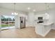 Modern kitchen with white cabinets, stainless steel appliances, and a large sliding glass door at 2252 Sw 168Th Loop, Ocala, FL 34473