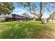 Expansive backyard with lush lawn, mature trees, and a large screened-in lanai area at 2431 Westwood Dr, Longwood, FL 32779