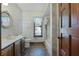 Bathroom featuring mosaic tile flooring and sink vanity with framed mirror, along with shower and window at 2431 Westwood Dr, Longwood, FL 32779