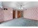 Spacious bedroom featuring floral wallpaper, blue carpet, and ceiling fan with light fixture at 2431 Westwood Dr, Longwood, FL 32779