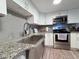 This kitchen features stainless steel appliances, gray subway tiles and a large undermount sink at 25704 Aberdovey Ave, Sorrento, FL 32776