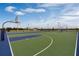 Outdoor basketball court with multiple hoops, vibrant blue and green surfacing, and lighting for evening play at 2660 Gouda Dr, Apopka, FL 32703