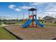 Community playground featuring a colorful slide, set on a wood chip base, with a tennis court in the background at 2660 Gouda Dr, Apopka, FL 32703