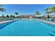 Community pool surrounded by lounge chairs and palm trees at 2664 Gouda Dr, Apopka, FL 32703