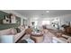 Bright open-concept living room featuring modern decor and seamless flow to the kitchen and dining areas at 2672 Gouda Dr, Apopka, FL 32703