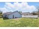 View of the backyard with an access door, small patio area, privacy fence and green grass at 2740 Regency Oak Ln, Orlando, FL 32833