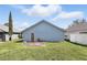 View of the backyard with an access door, small patio area, and green grass at 2740 Regency Oak Ln, Orlando, FL 32833
