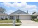 Charming single-story home featuring a well-maintained lawn and attached two-car garage at 2740 Regency Oak Ln, Orlando, FL 32833