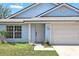 Close-up of the inviting front entrance with potted plants and a well-manicured lawn at 2740 Regency Oak Ln, Orlando, FL 32833