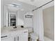 Bright bathroom featuring a single sink vanity, a large mirror, and a shower-tub combo with a curtain at 2801 Lido Key Ct, Kissimmee, FL 34747