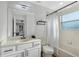 Bright bathroom featuring a single sink vanity, a large mirror, and a shower-tub combo with a curtain at 2801 Lido Key Ct, Kissimmee, FL 34747