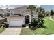 Inviting two-story home with manicured lawn, arched entryway, and a two car garage at 2801 Lido Key Ct, Kissimmee, FL 34747