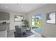 Cozy dining area with a round glass table, modern chairs, and a sliding glass door leading to the backyard at 2936 Moulin Rd, Davenport, FL 33837
