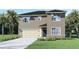 Two-story home with a two-car garage, well-maintained lawn, and complemented by palm trees at 2936 Moulin Rd, Davenport, FL 33837