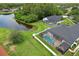 Aerial view showcases two screened-in pools, a backyard pond, and lush landscaping at 3180 Pawleys N Loop, St Cloud, FL 34769