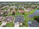 Aerial view showcases a home with a pool, lush lawns, landscaping, and pond in a desirable neighborhood at 3180 Pawleys N Loop, St Cloud, FL 34769