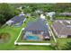 Aerial view of the house featuring a screened-in pool, lush lawn, and well-maintained landscaping at 3180 Pawleys N Loop, St Cloud, FL 34769