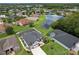 Aerial view of a beautiful home, a screened pool, a backyard pond, and lush landscaping in a friendly neighborhood at 3180 Pawleys N Loop, St Cloud, FL 34769