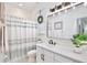 Bathroom featuring a vanity with white marble countertops and a white and gray striped shower curtain at 3180 Pawleys N Loop, St Cloud, FL 34769
