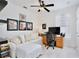 Bedroom with white sofa, ceiling fan and wood desk and tile floors at 3180 Pawleys N Loop, St Cloud, FL 34769