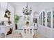 Bright dining room with a glass table, elegant chandelier, and white furnishings, perfect for entertaining at 3180 Pawleys N Loop, St Cloud, FL 34769