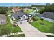 Exterior elevation view of a black and white home with lush lawn, landscaping, long driveway, and a screened pool at 3180 Pawleys N Loop, St Cloud, FL 34769