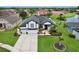 Exterior elevation view of a black and white home featuring a well-manicured lawn, landscaping, and a large driveway at 3180 Pawleys N Loop, St Cloud, FL 34769