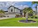 Elegant home featuring a three-car garage, lush landscaping, and a circular flower bed enhancing curb appeal at 3180 Pawleys N Loop, St Cloud, FL 34769