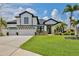 Stunning two-story home featuring a three-car garage, lush landscaping, and a well-manicured lawn at 3180 Pawleys N Loop, St Cloud, FL 34769