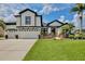 Charming home with a three-car garage, striking black and white accents, and beautiful front yard landscaping at 3180 Pawleys N Loop, St Cloud, FL 34769
