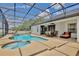 Beautiful backyard showcasing a screened-in pool, spa, patio and outdoor dining area at 3180 Pawleys N Loop, St Cloud, FL 34769