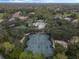Aerial view of multiple tennis courts and large pool surrounded by trees in a community setting at 3214 Regal Crest Dr, Longwood, FL 32779