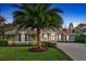 Charming single-story home featuring lush landscaping, a well-manicured lawn, and a prominent palm tree at 3214 Regal Crest Dr, Longwood, FL 32779