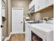 Bright laundry room with modern washer and dryer, storage cabinets and wood-look floors at 3214 Regal Crest Dr, Longwood, FL 32779