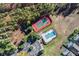 Aerial view showcasing a community tennis court, pool, and parking nestled among lush trees at 335 Prestwick Dr, Davenport, FL 33897