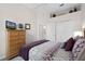 Bright bedroom featuring a plush bed, wood dresser with TV, and large closet doors at 335 Prestwick Dr, Davenport, FL 33897