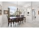 Formal dining room features a chandelier over a wood table with large windows and tile flooring at 335 Prestwick Dr, Davenport, FL 33897