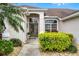 Elegant front entrance with double doors, decorative transom window, and lush landscaping at 335 Prestwick Dr, Davenport, FL 33897