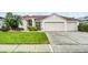 Charming single-story home with a well-manicured lawn, two-car garage, and beautifully landscaped front yard at 335 Prestwick Dr, Davenport, FL 33897