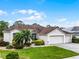Inviting single-story home features a lush green lawn, complemented by well-maintained landscaping and a two-car garage at 335 Prestwick Dr, Davenport, FL 33897