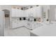 Bright kitchen with white cabinets, white appliances, light countertops, and tile flooring at 335 Prestwick Dr, Davenport, FL 33897