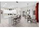 Kitchen area with white cabinets and stainless steel appliances with bar seating and a dining area at 335 Prestwick Dr, Davenport, FL 33897