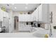 Bright kitchen with white appliances, white cabinets, light countertops, and tile flooring at 335 Prestwick Dr, Davenport, FL 33897