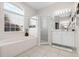 Bright main bathroom with a glass enclosed shower, soaking tub and dual sink vanity at 335 Prestwick Dr, Davenport, FL 33897