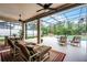 Screened-in patio with multiple lounge chairs, dining set, and view of pool at 335 Prestwick Dr, Davenport, FL 33897