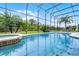 A screened pool and hot tub feature plenty of patio space, comfortable seating, and backyard views at 335 Prestwick Dr, Davenport, FL 33897