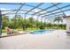 Large screened-in pool area with chairs and lush green surroundings at 335 Prestwick Dr, Davenport, FL 33897