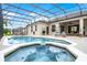 A stunning screened-in pool area features a heated spa and ample seating, perfect for relaxing and entertaining at 335 Prestwick Dr, Davenport, FL 33897