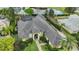 Stunning aerial view of a home with meticulous landscaping, a dark roof, and a serene lake backdrop at 3358 Fernlake Pl, Longwood, FL 32779