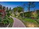 Manicured backyard featuring a brick pathway, lush landscaping, and ambient lighting at 3358 Fernlake Pl, Longwood, FL 32779